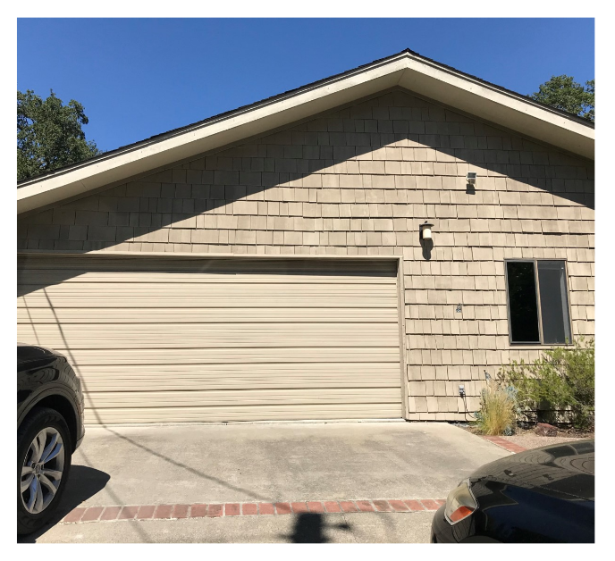 Beige house with a plain exterior, single window, and two cars parked in the driveway, showing the original design before using Renoworks Pro.